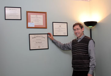 Dr. Maryott with degrees and diplomas in his office